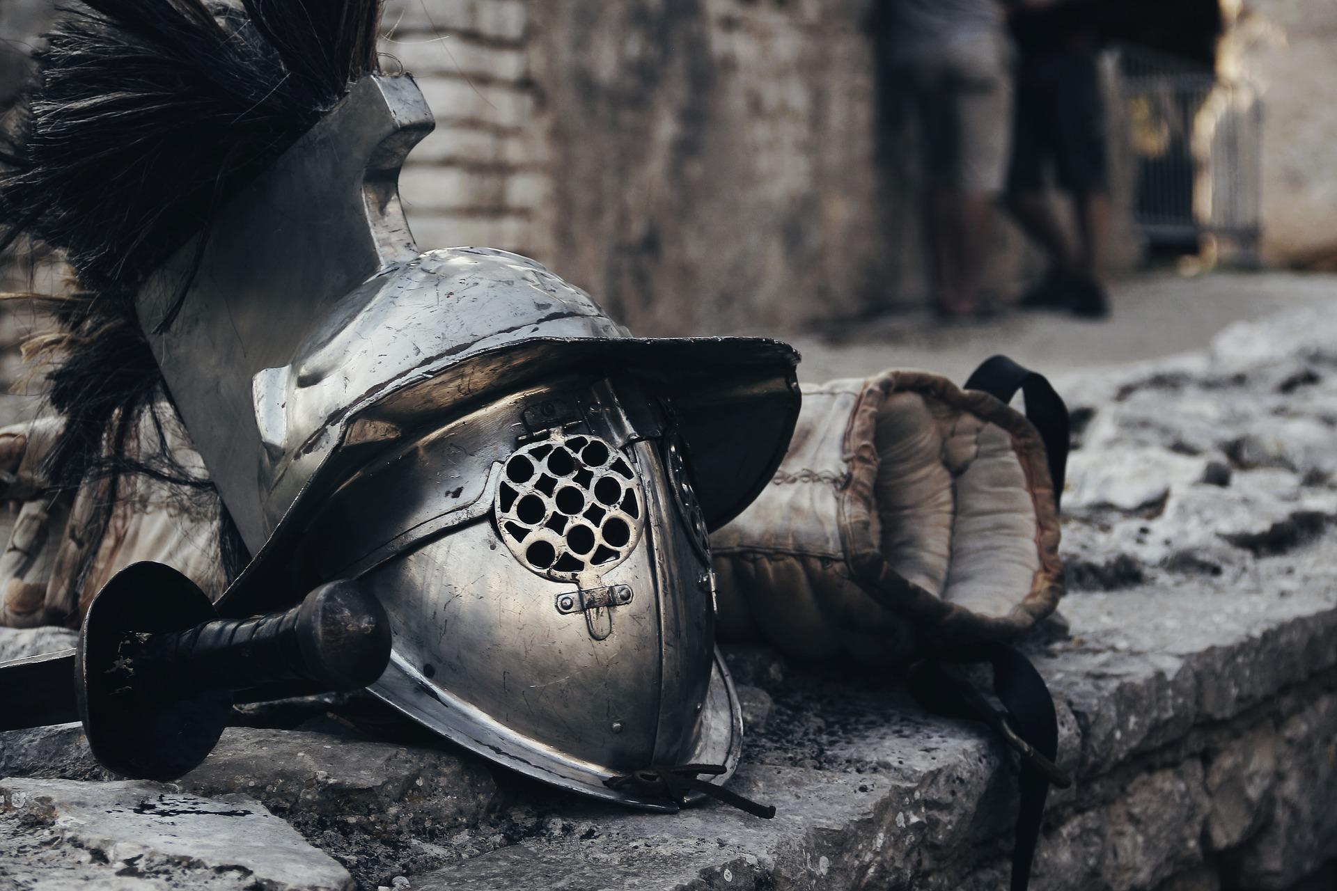 Gladiatorenhelm und Ausrüstung auf Mauer (Bild von ArsAdAstra auf Pixabay)