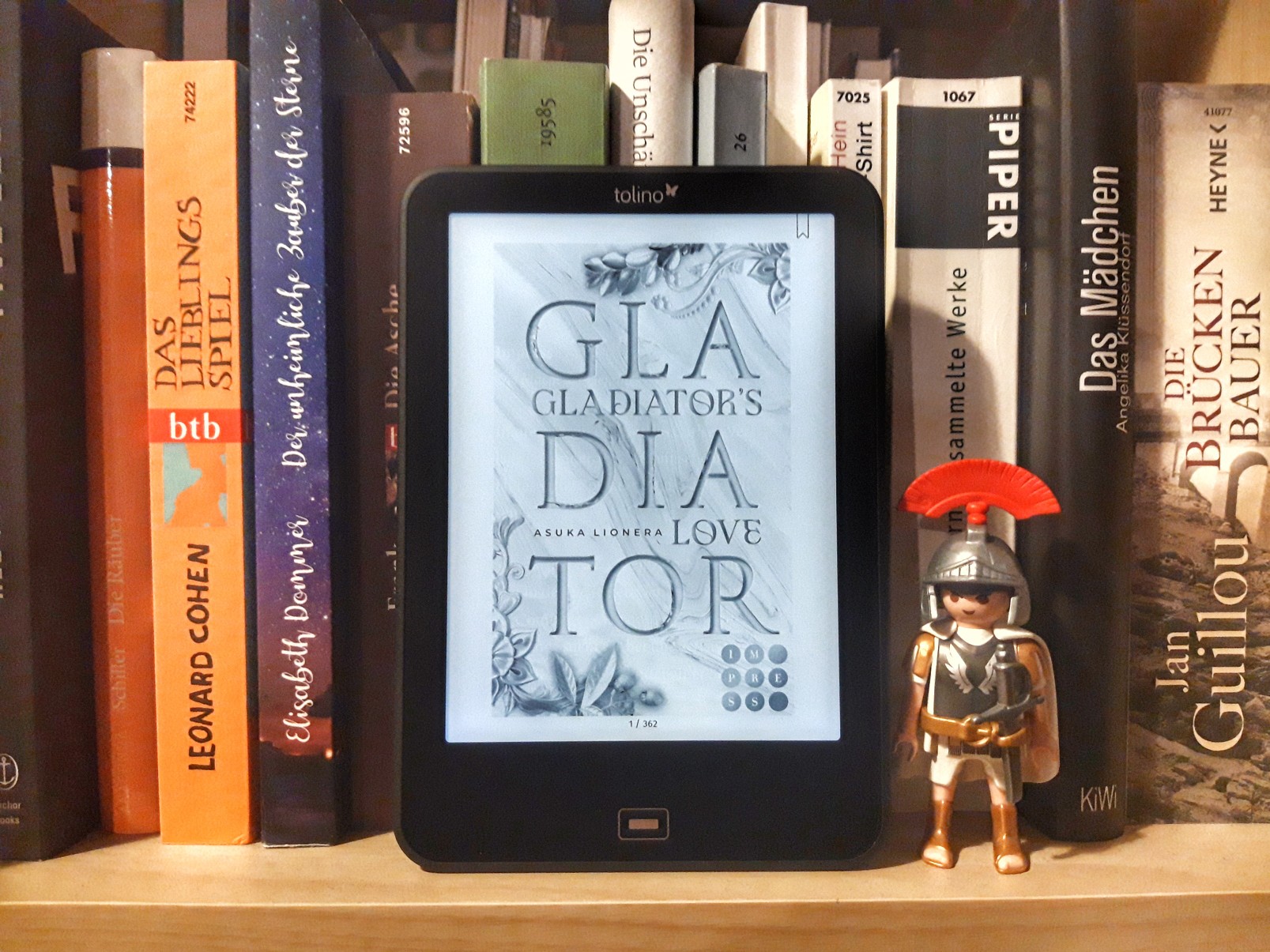E-Book-Reader mit "Gladiator's Love" von Asuka Lionera - daneben ein Playmobil-Zenturio