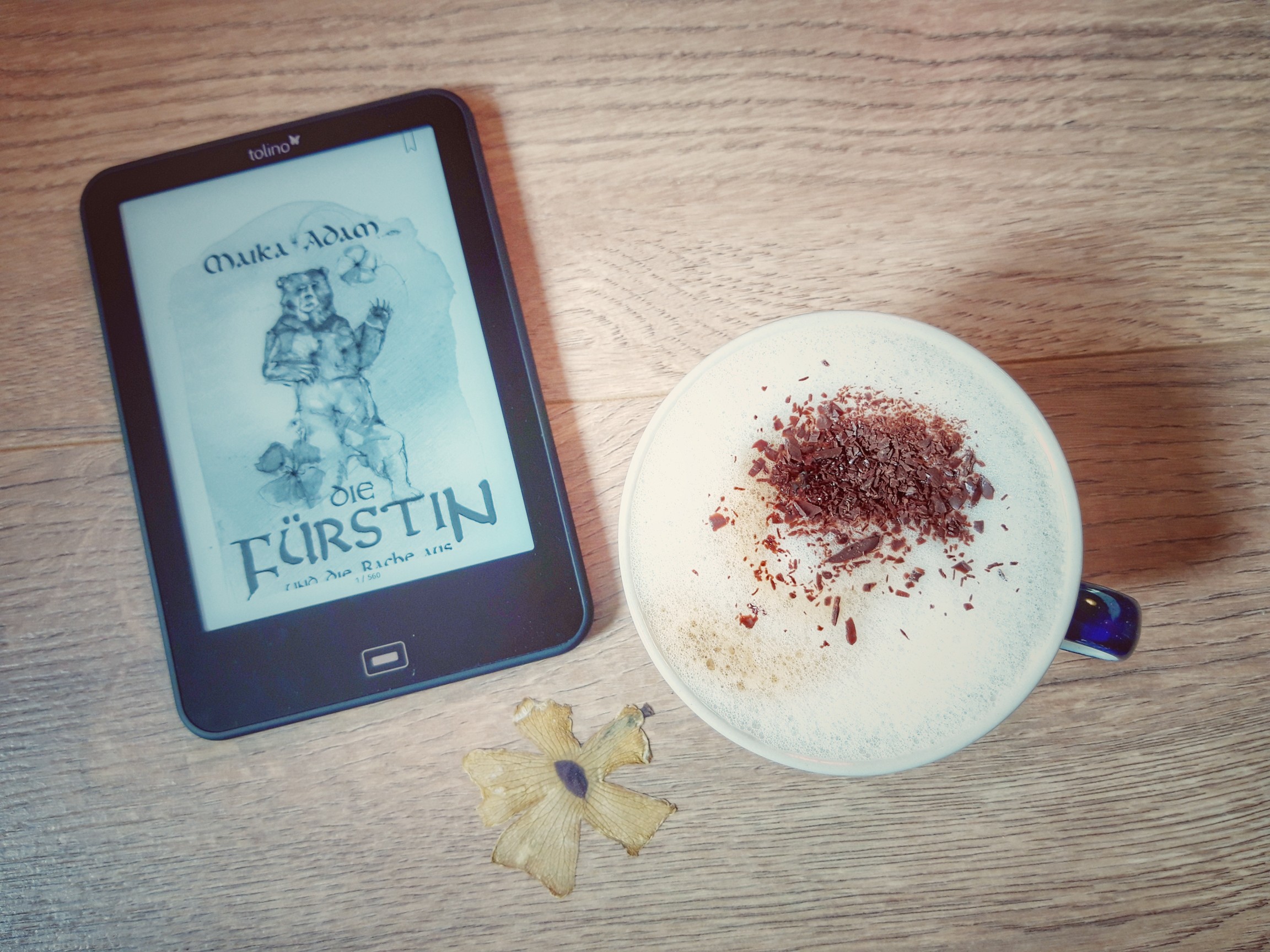 Ein E-Book-Reader mit dem E-Book "Die Fürstin und die Rache aus Oran" von Maika Adam neben einer Tasse Kaffee
